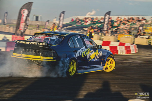 BMW E46 sliding in tyre smoke in front of a packed grandstand