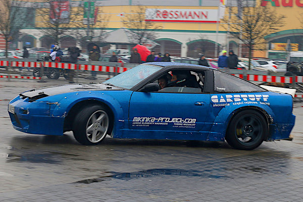 Blue Nissan 200SX with CarStuff and Mikinka-Projekt.com decals drifting in the rain on a car park