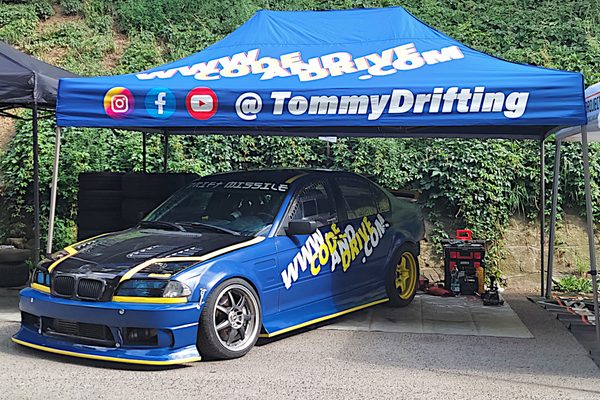 BMW E46 under the blue TommyDrifting paddock tent